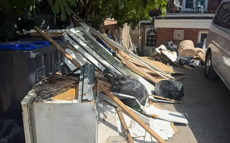 Side yard piled with construction debris before Breath Out hauled it